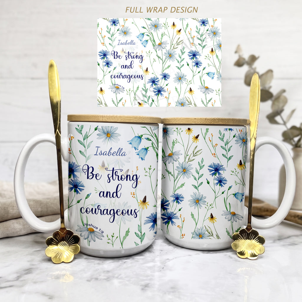 Personalized white ceramic mug featuring a blue watercolor wildflower design and the Christian bible verse Joshua 1:9 "Be strong and courageous" with a custom name. Available in an 11oz classic coffee cup style or an elegant 15oz premium gift set with a wooden bamboo lid and a golden flower spoon on a bright, minimalist marble background.