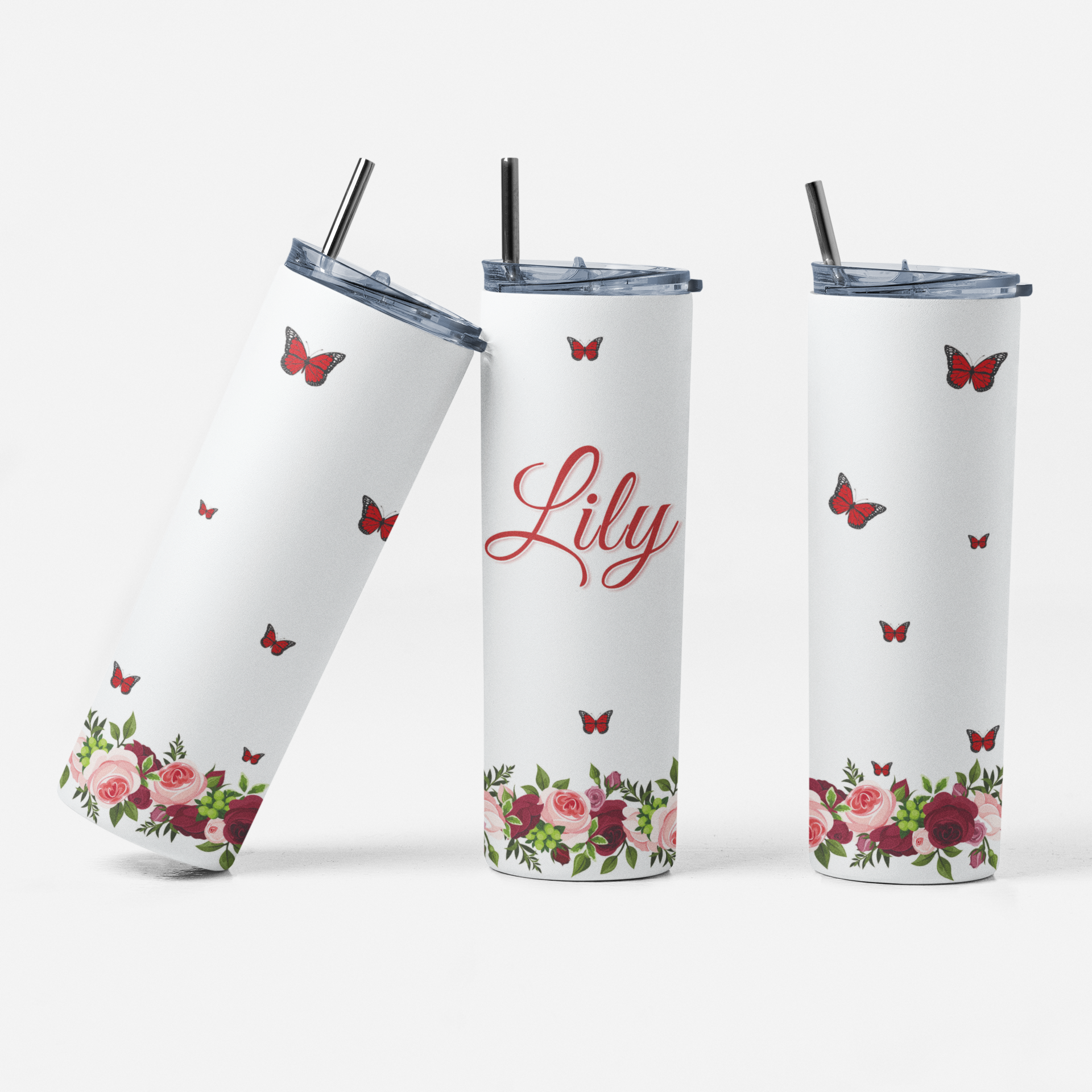 Three white tumblers with floral and butterfly designs on a white background