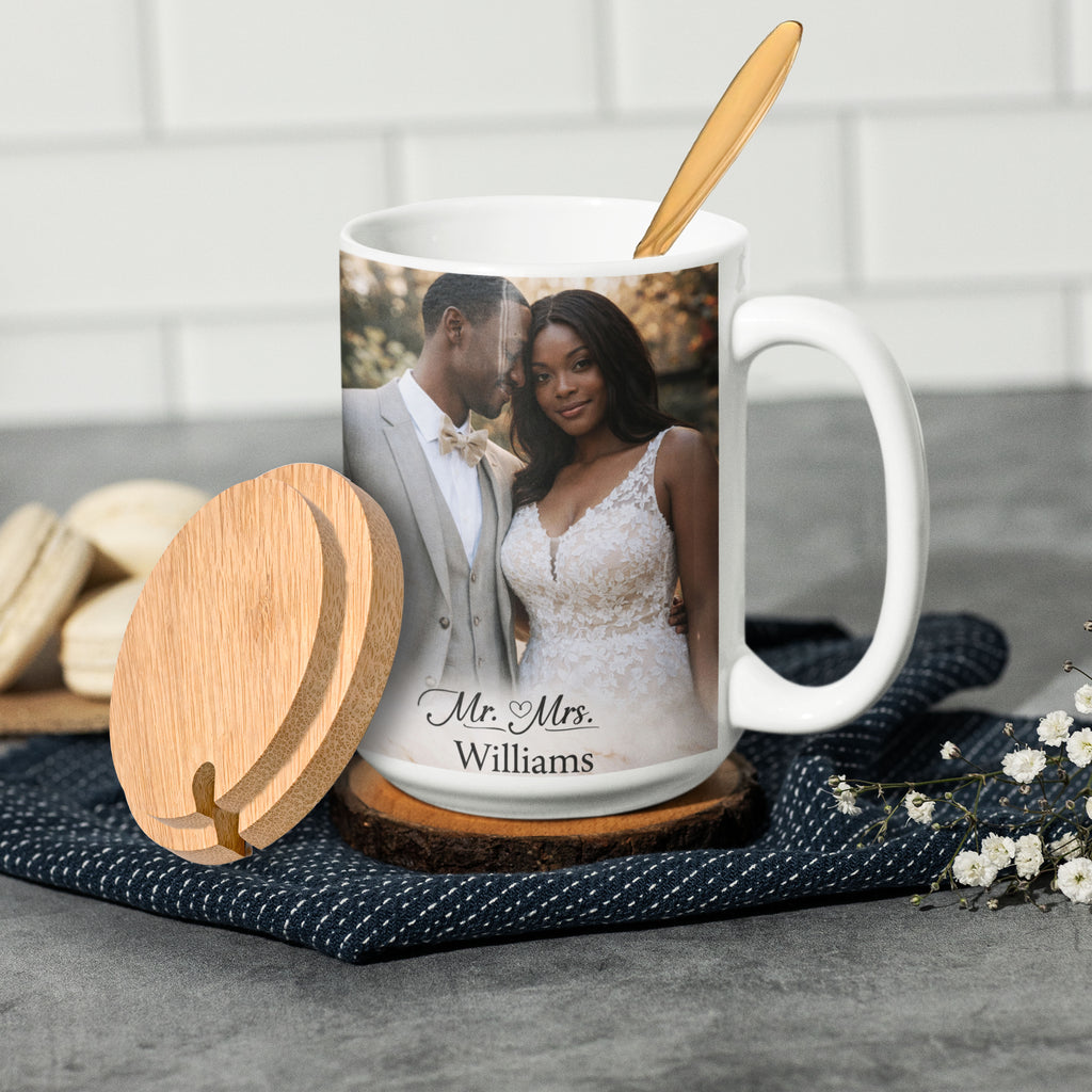 Example of a personalized 15 oz white ceramic mug with custom wedding photo and names, bamboo lid, and gold-tone spoon. Design shown is for display purposes only.