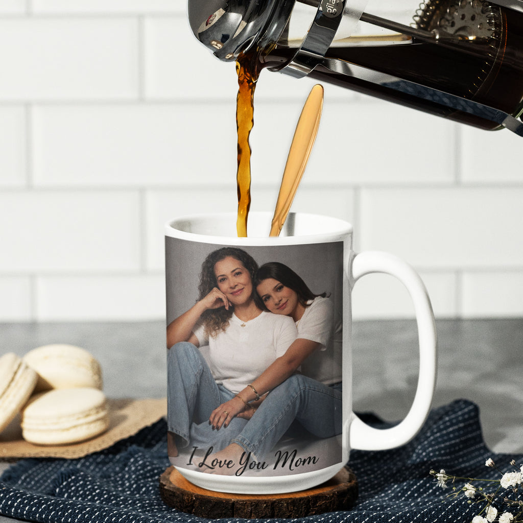 Example of a personalized 15 oz white ceramic photo mug with custom mother and daughter photo and text, shown being filled with coffee. Design is for display purposes only.